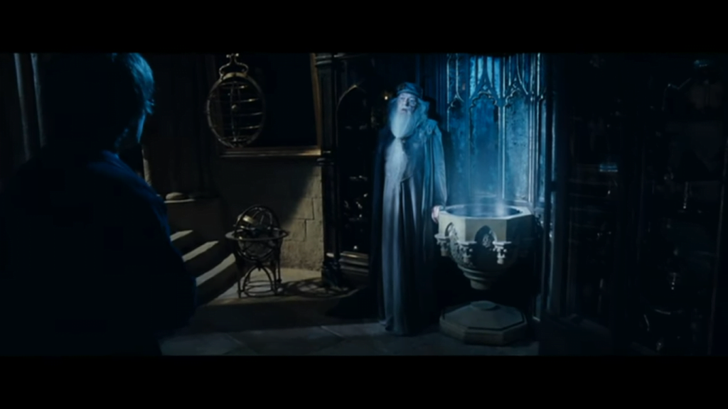 Dumbledore dengan pensieve di sebelah kirinya